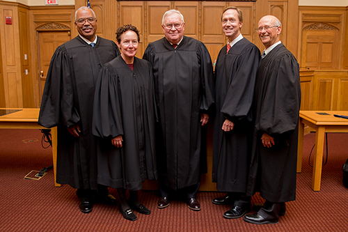 Five judges in robes.
