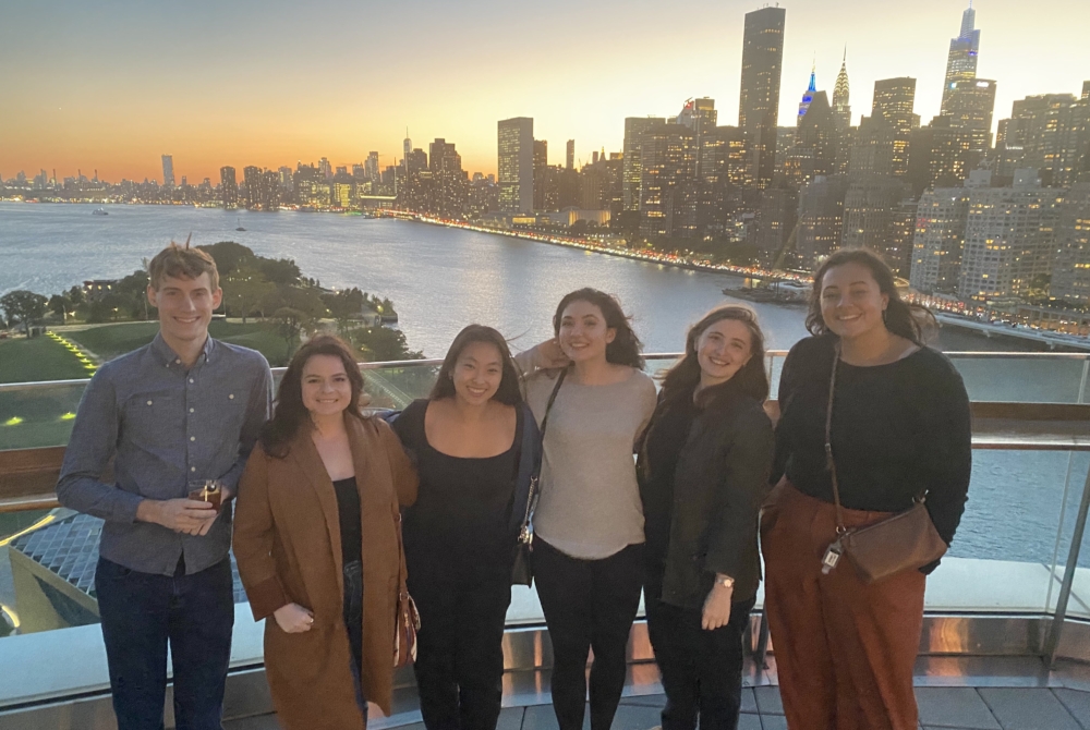 group of students on a rooftop with NYC skyline behind them