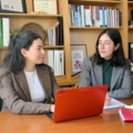 two students and a faculty member talking in an office