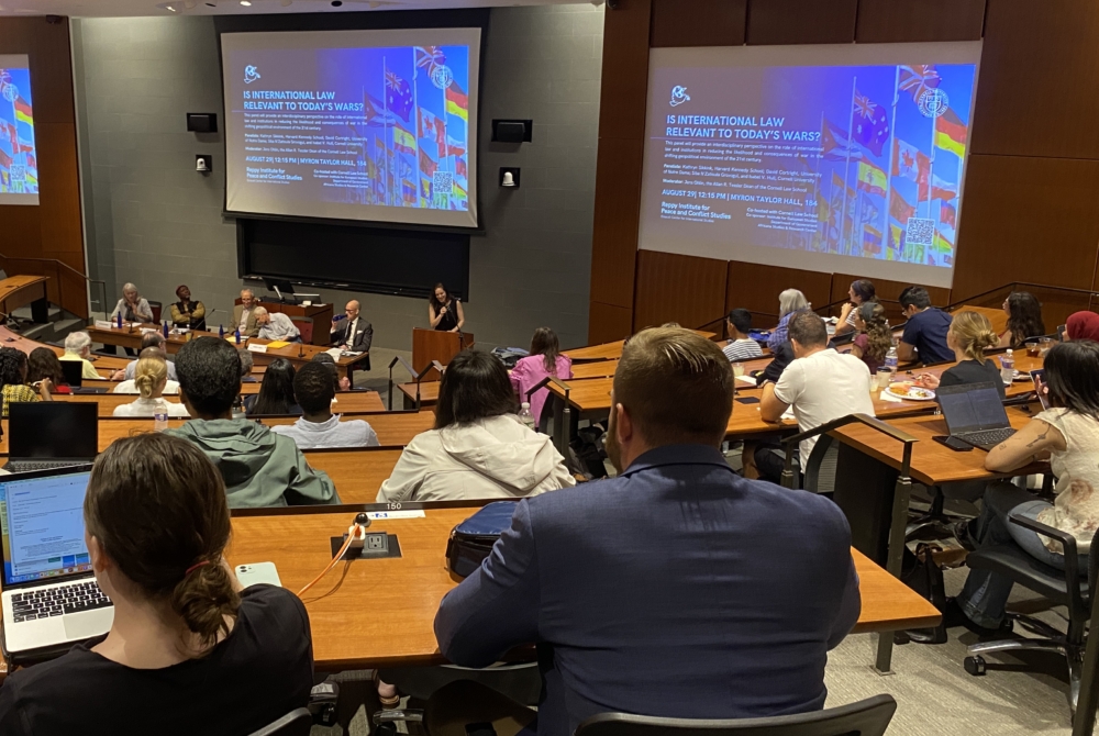 Event participants sitting in large classroom listening to the panel.