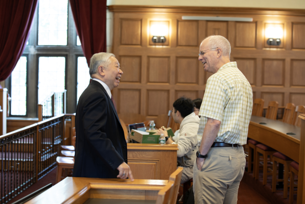 Jonathan Zhu talking with professor at his lecture in Moot Court Room at Cornell Law School