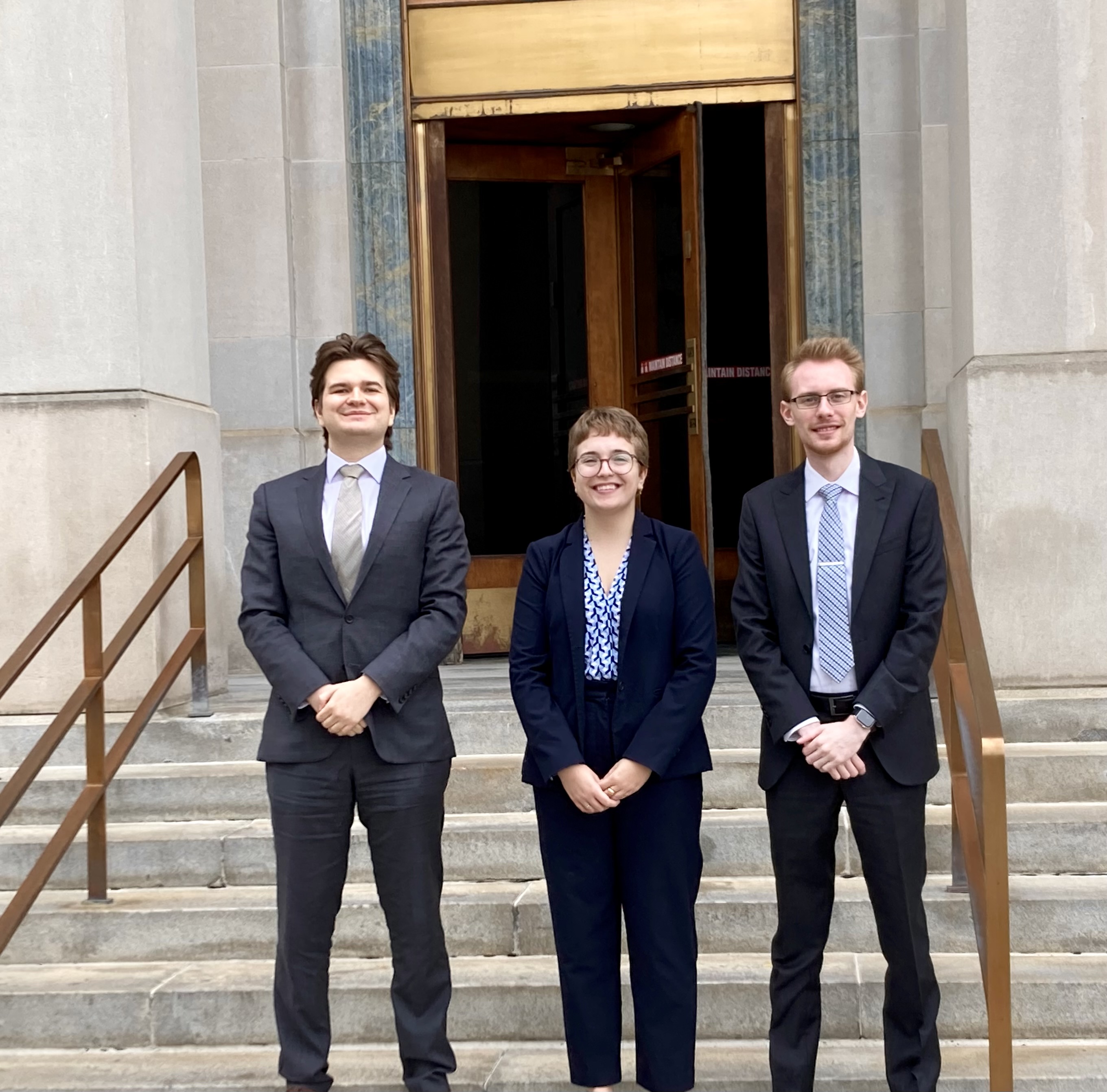 three students outside a courthouse